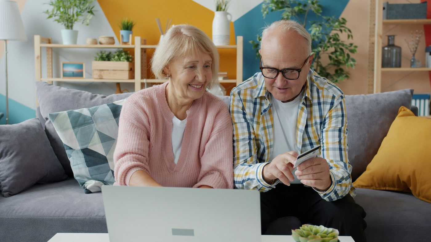 Elderly couple relaxing comfortably together at home on the sofa